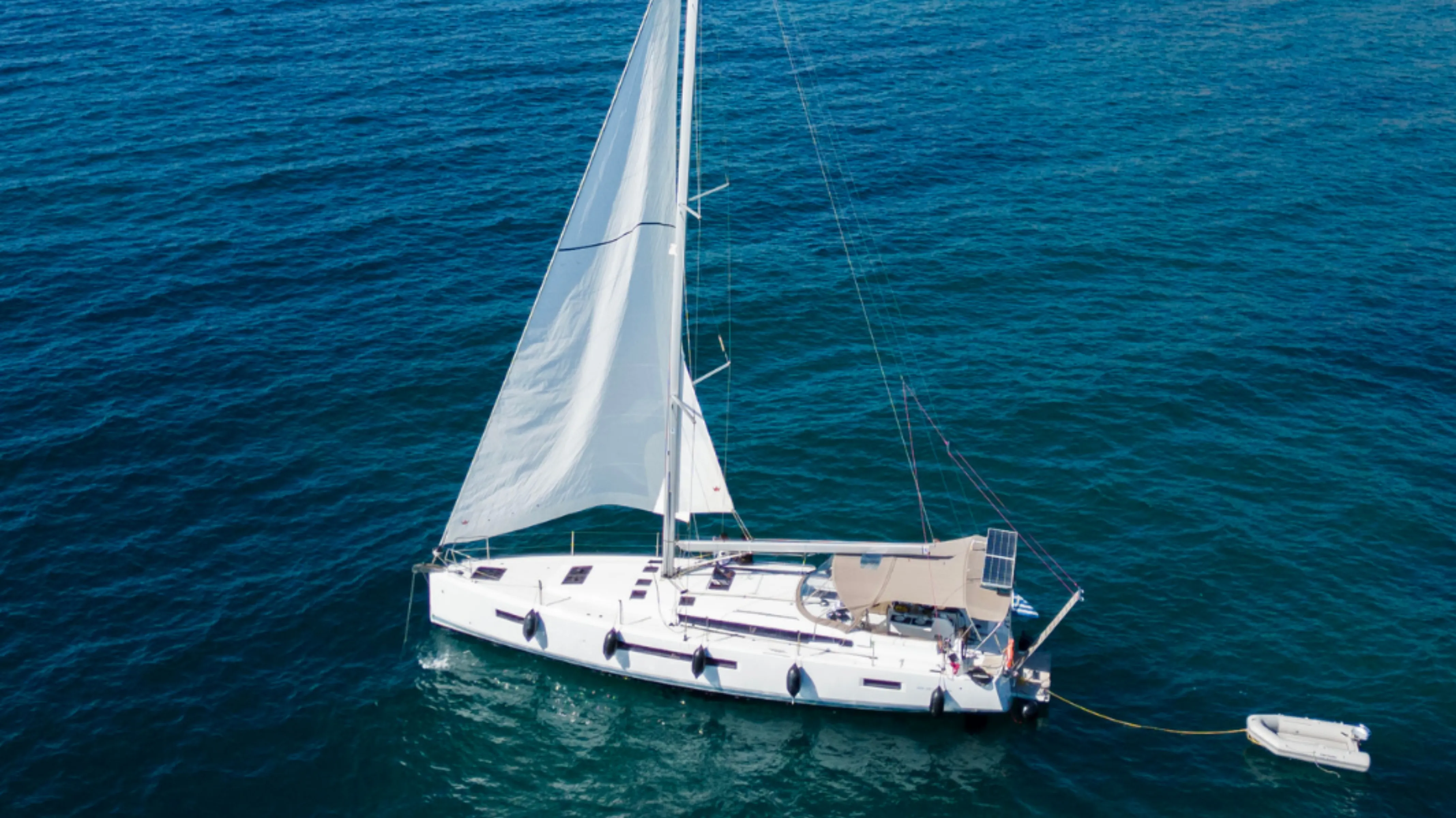A monohull sailing yacht heeling into the breeze under full sail
