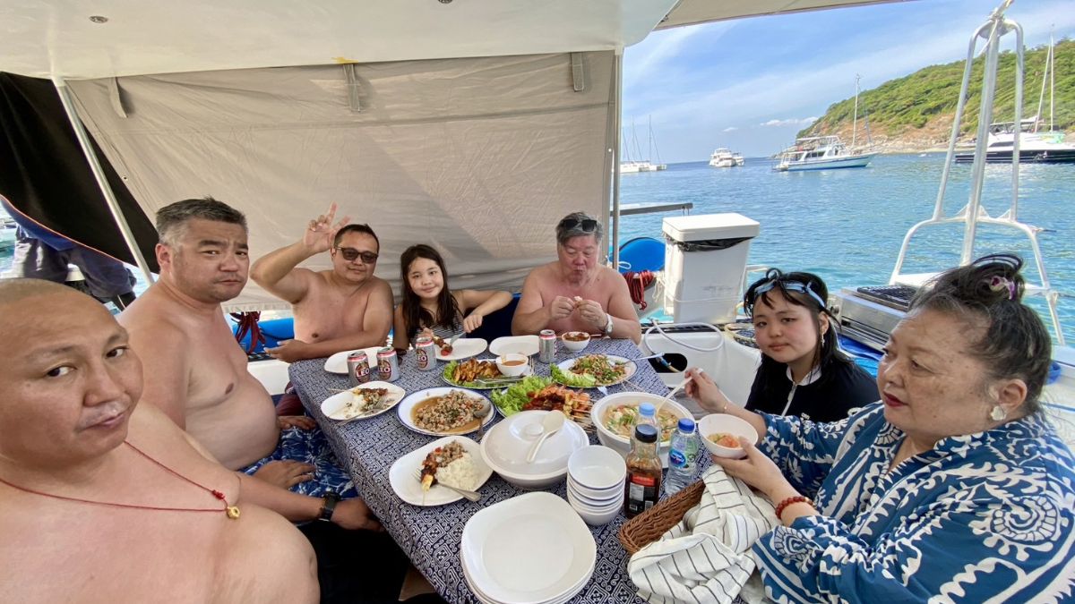 Guests sharing a Thai meal onboard SY Shindig at anchor